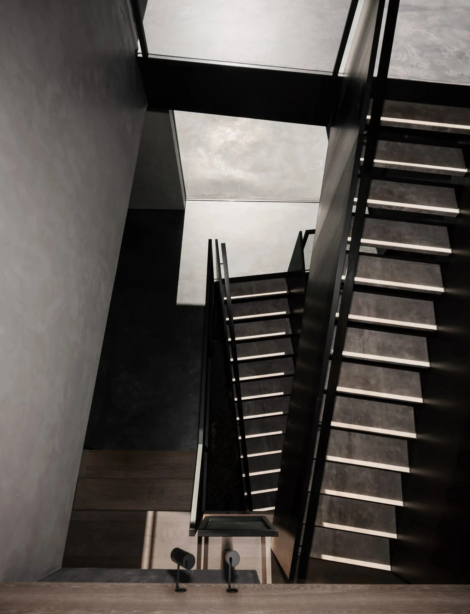 An industrial-style staircase constructed from concrete, viewed from an elevated angle.