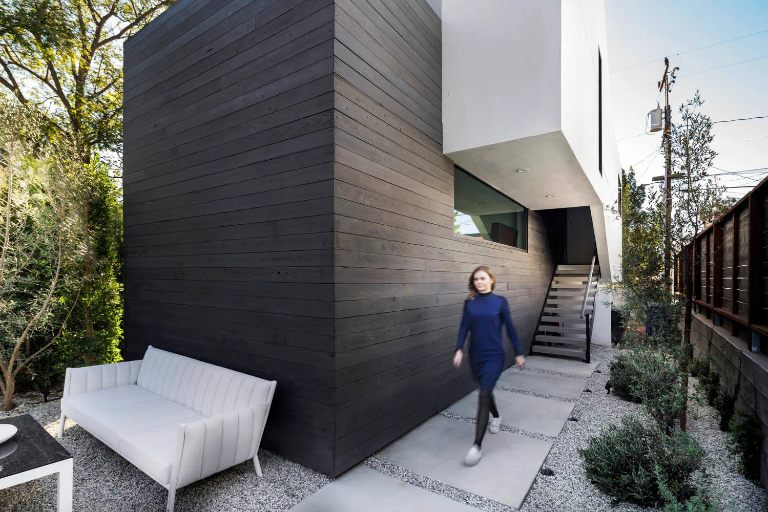 A modern residential exterior featuring concrete and wood materials.