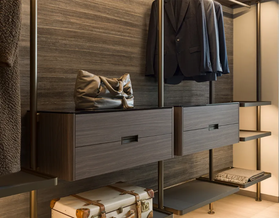 Modern solid wood dresser with leather handles in a minimalist closet space.