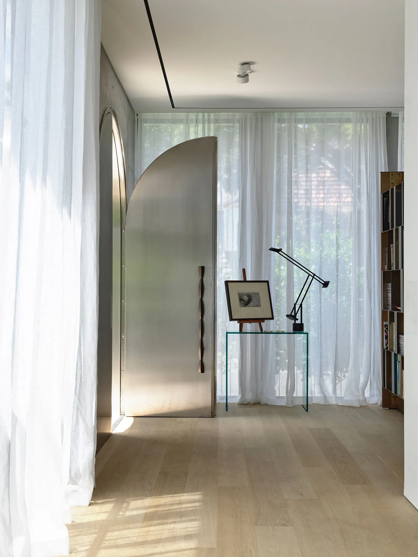 Modern interior design featuring a glass window, wooden floor and light fixture.
