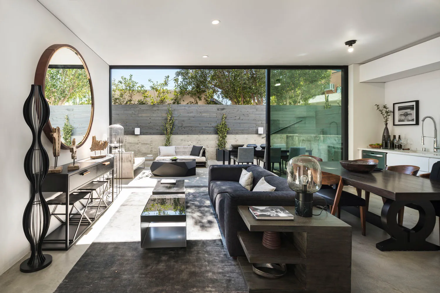 Modern living room featuring a concrete fireplace, black furniture, and a sleek design.