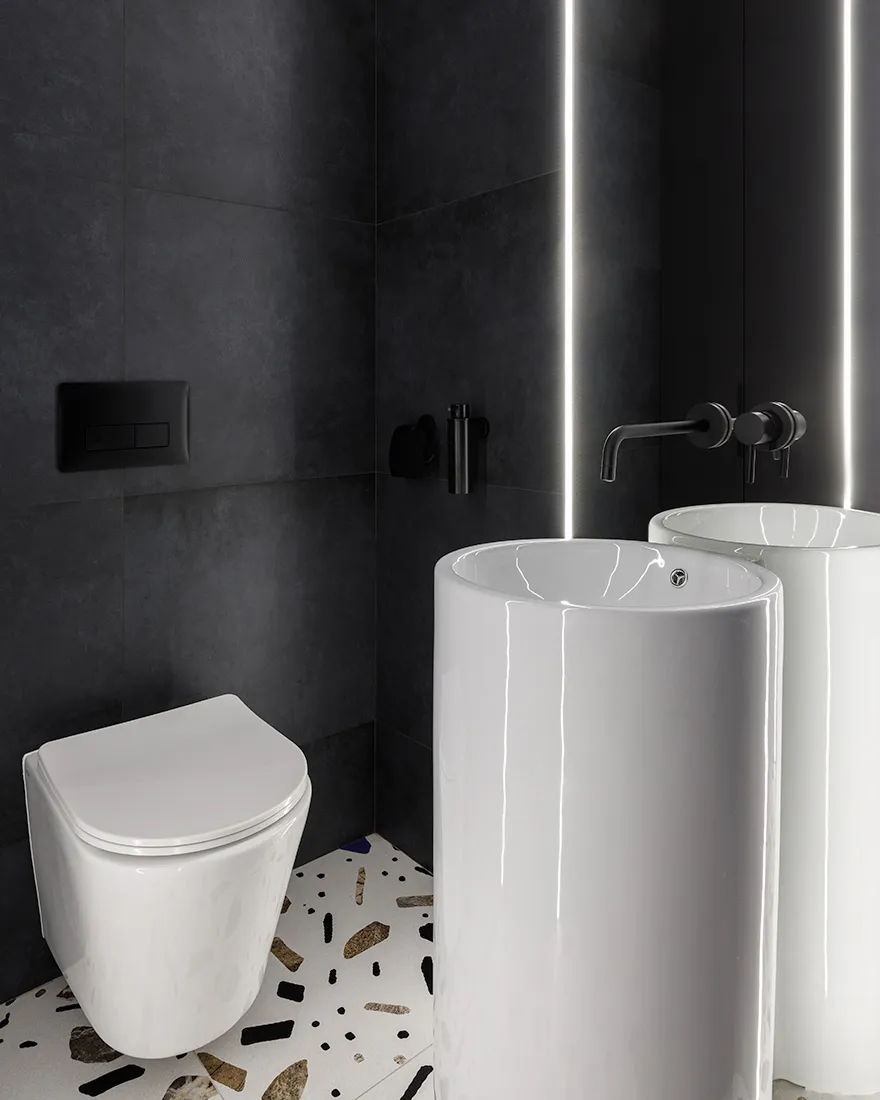Modern minimalist bathroom with black ceramic tiles and a white freestanding sink with a terrazzo floor.