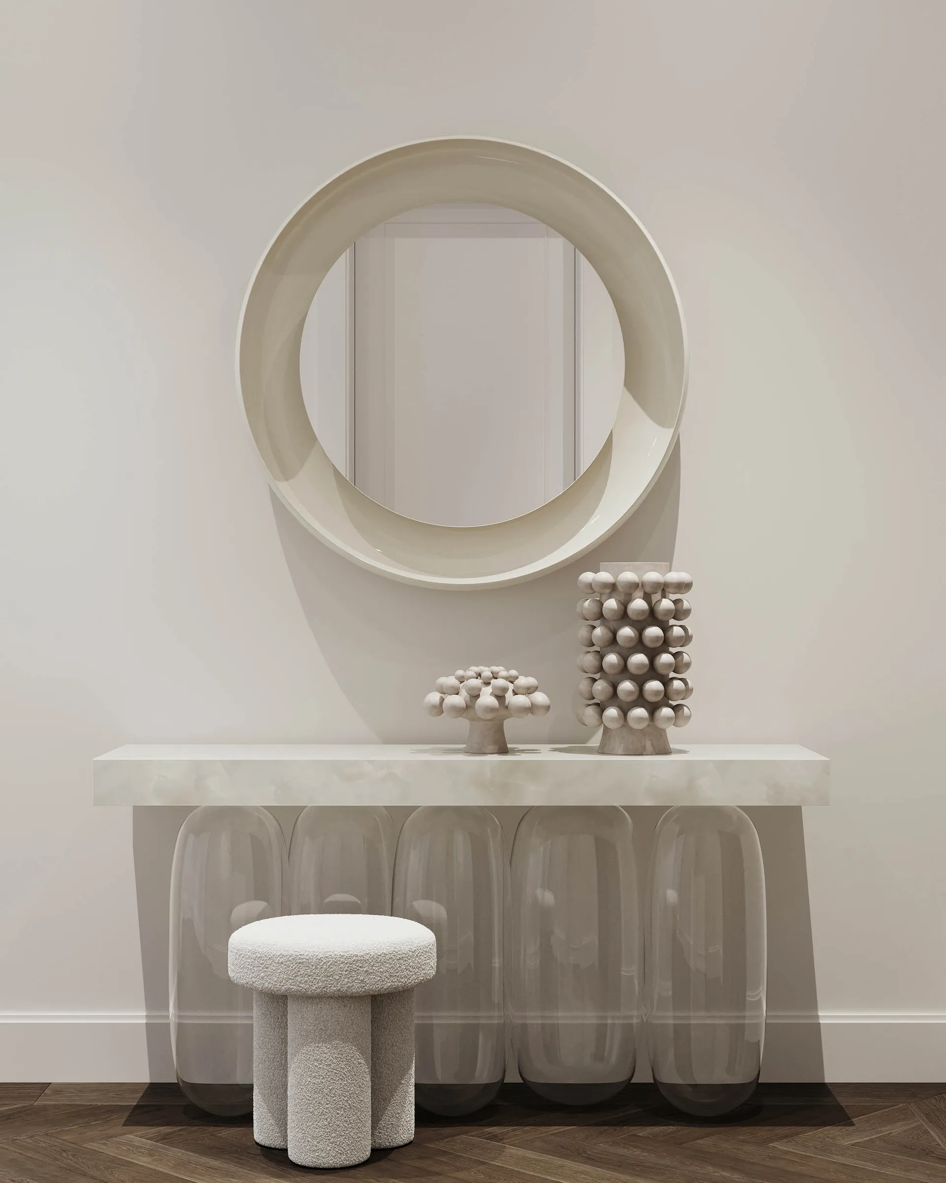 A modern entryway featuring concrete and glass materials, with a circular mirror and decorative objects on a sleek console ta