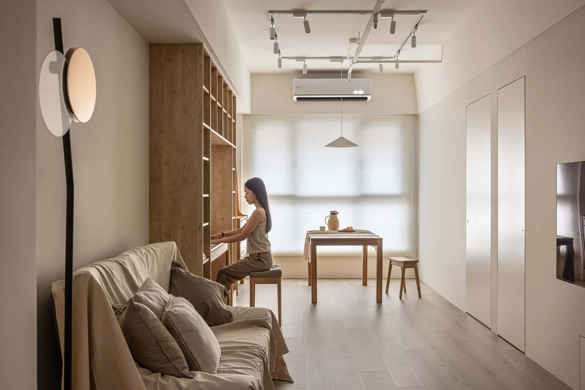 A minimalist residential interior featuring wooden furniture and concrete accents.