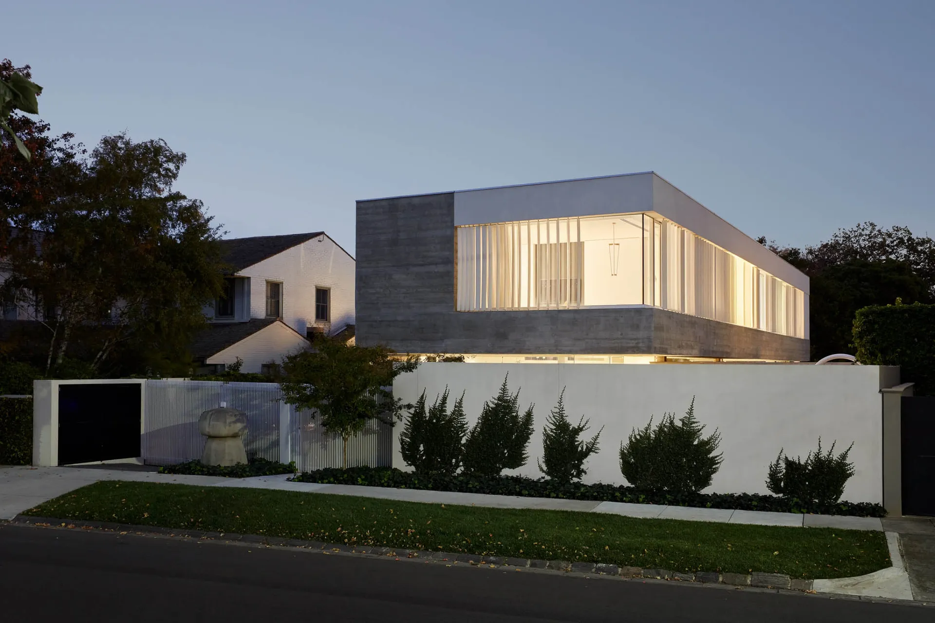 A modern house with a concrete exterior during twilight.