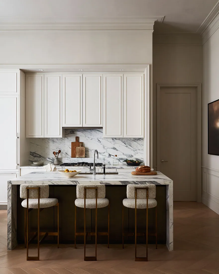 Modern kitchen featuring a marble countertop and white cabinets.