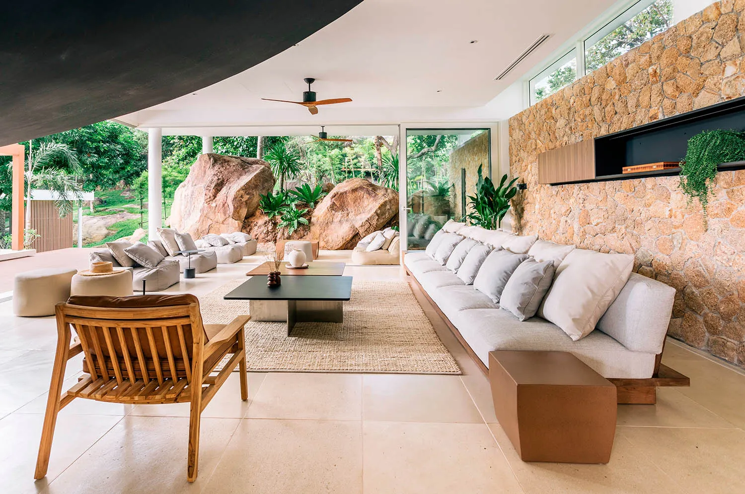 A modern minimalist living room with a concrete floor and reflection from a large window, featuring sleek furniture and natur