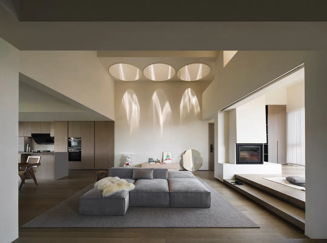 A modern living room with a neutral color palette featuring a sectional sofa, area rug, and minimalist decor.