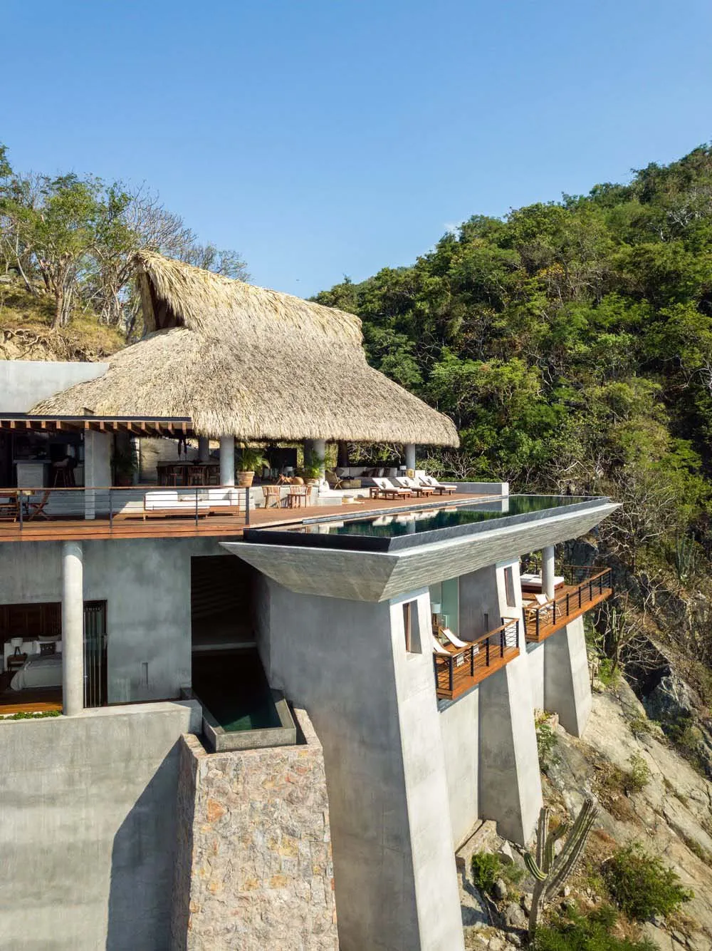 Modern residential architecture featuring concrete and thatched roofing.