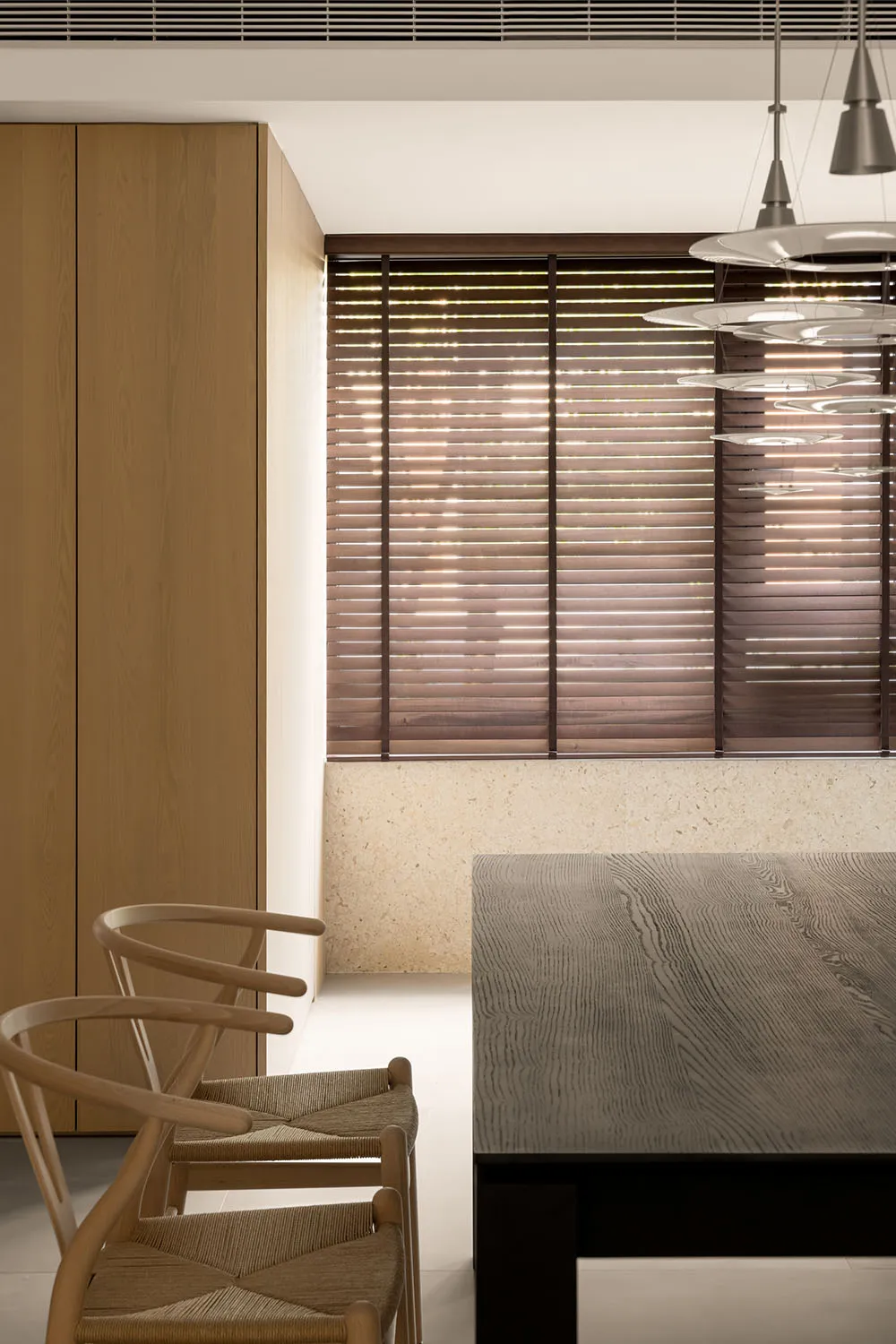 Modern dining room featuring wooden furniture and stone floor.