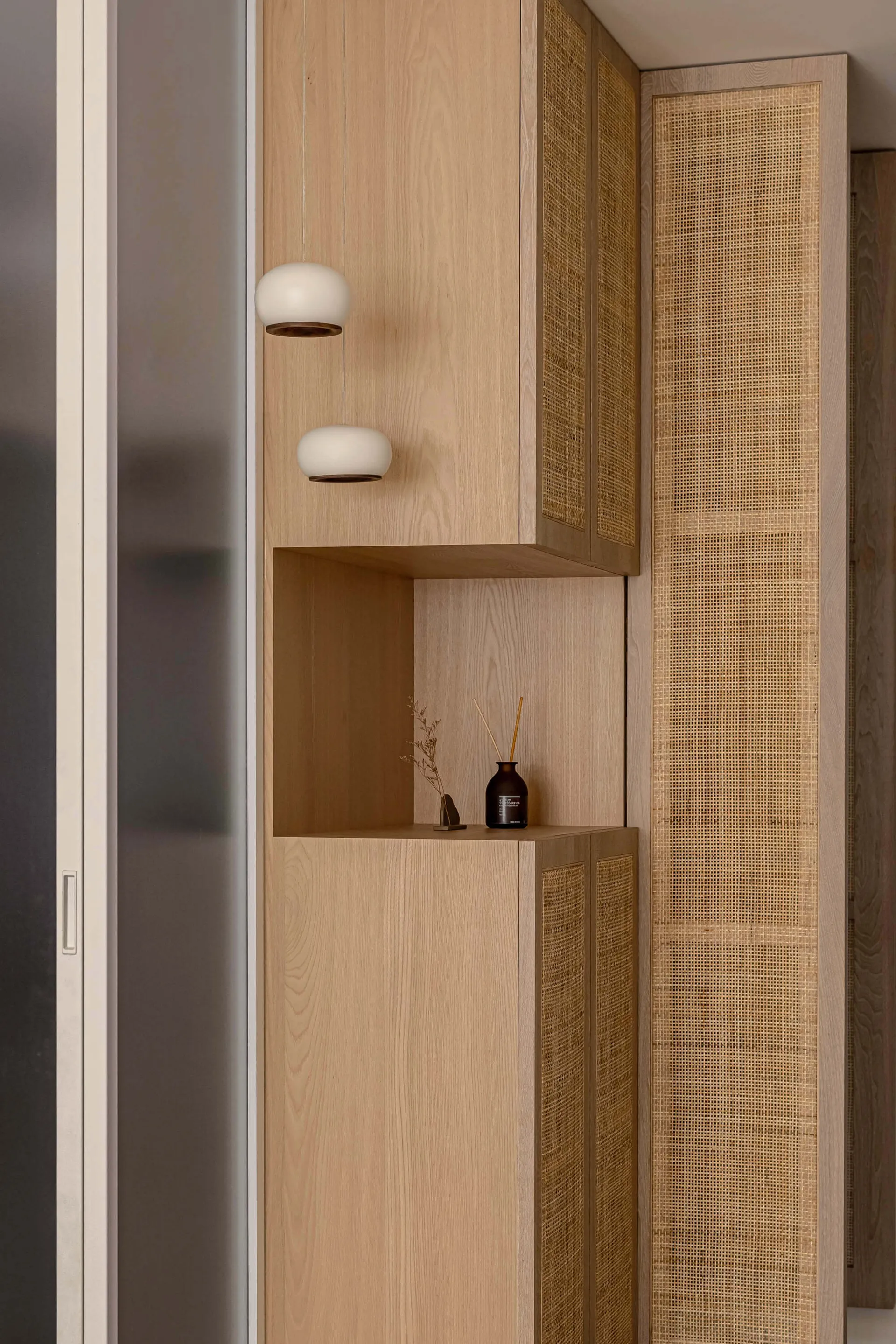 Modern interior design featuring a wooden storage cabinet with built-in lighting and a decorative shelf.