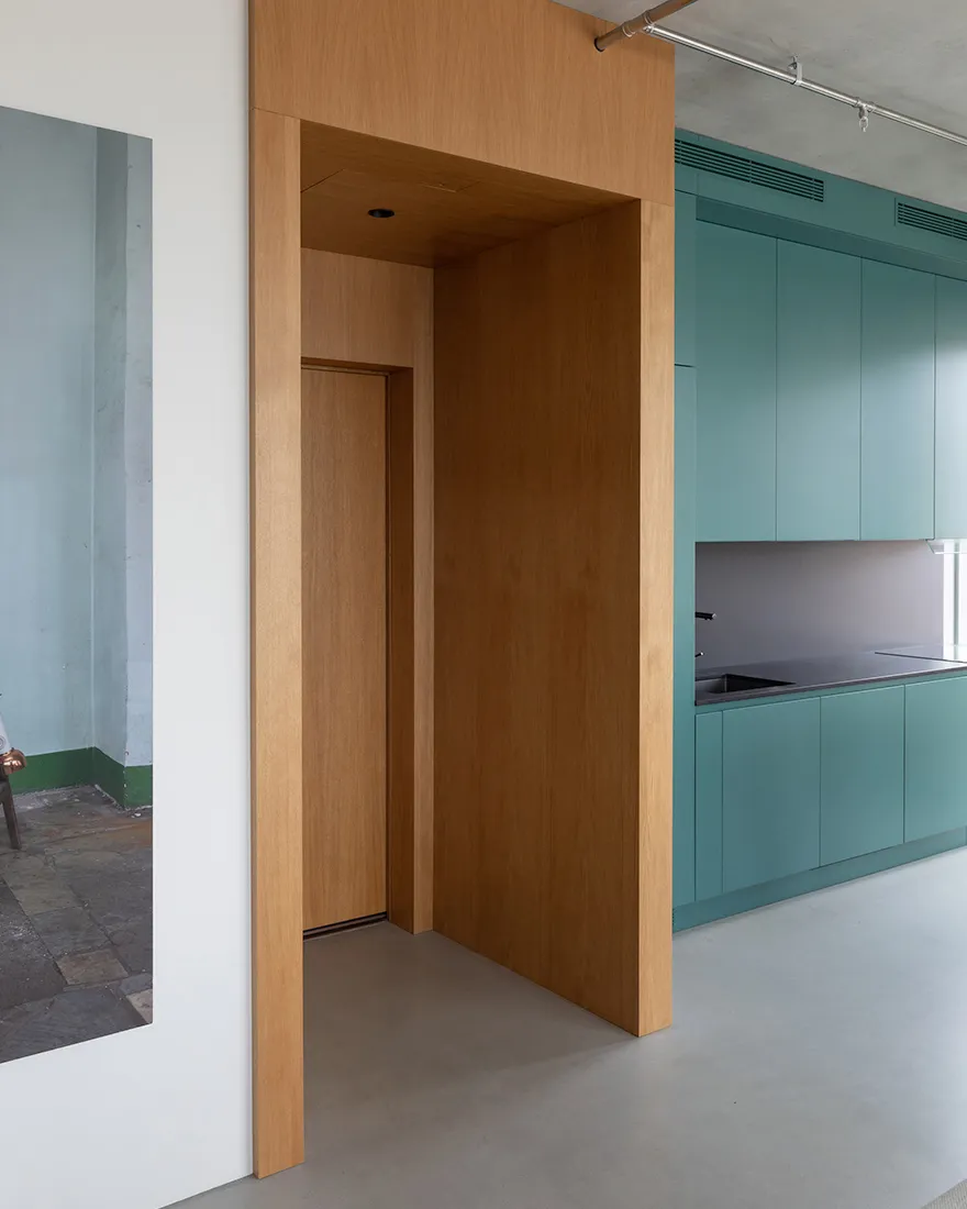 Modern, minimalist kitchen with wooden cabinets and flooring.