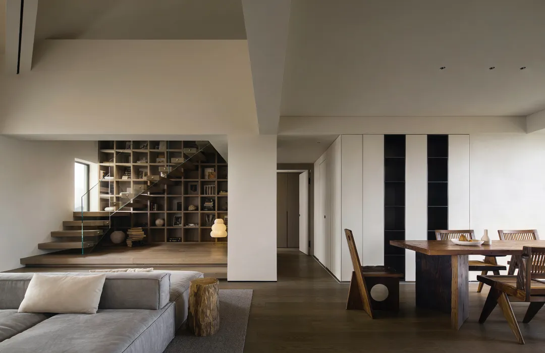 A modern interior design featuring wooden furniture, concrete walls, and glass elements.