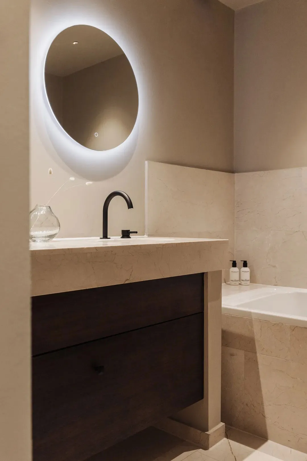 Modern bathroom featuring a marble countertop and sink with minimalist design elements.