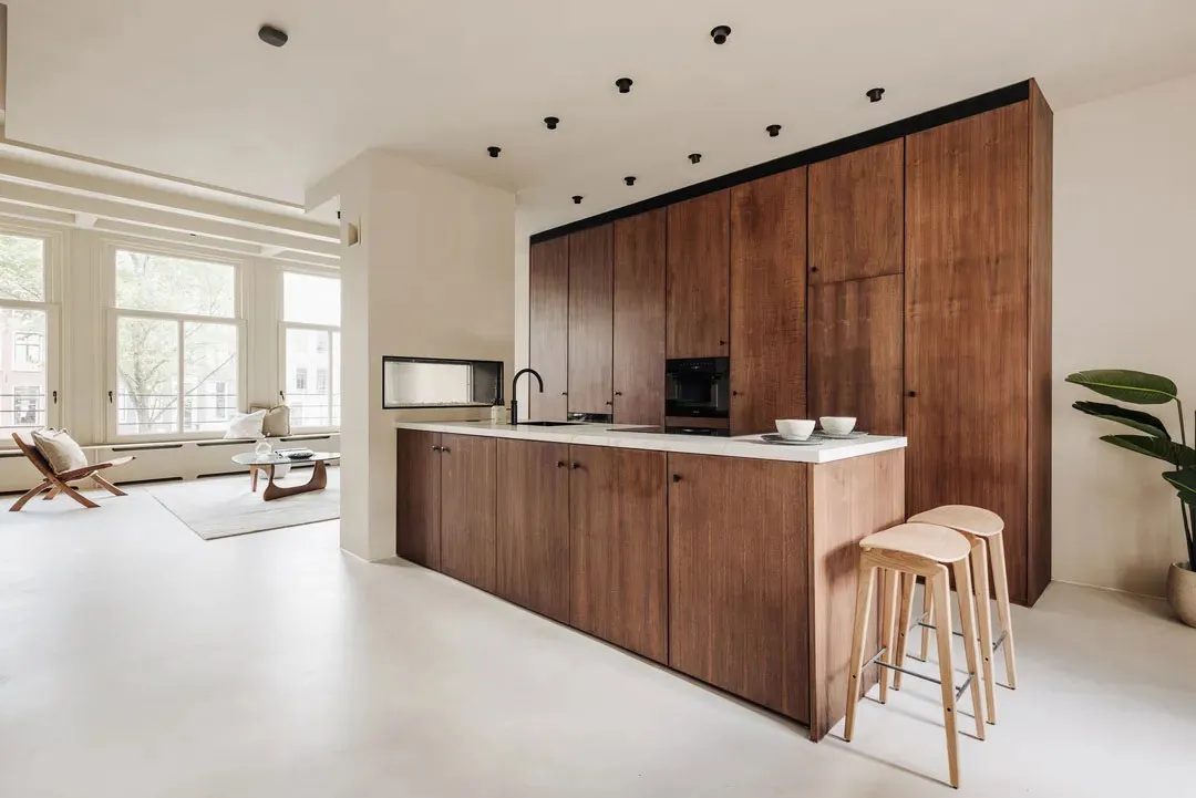 A modern kitchen featuring wooden cabinets and white flooring.