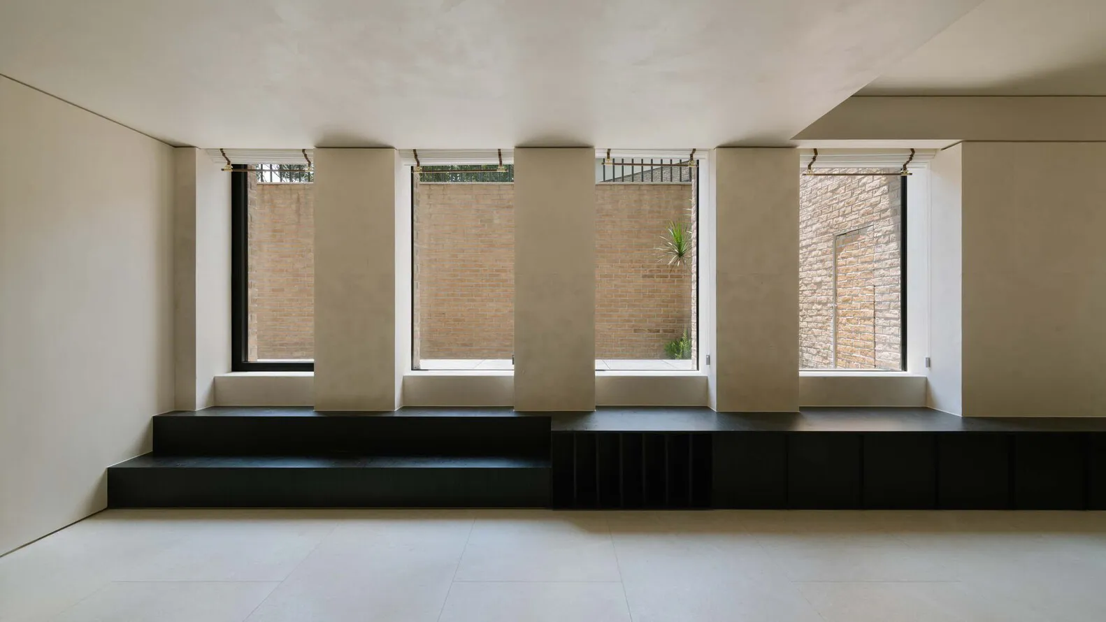 A minimalist interior design featuring concrete elements in a living room setting.