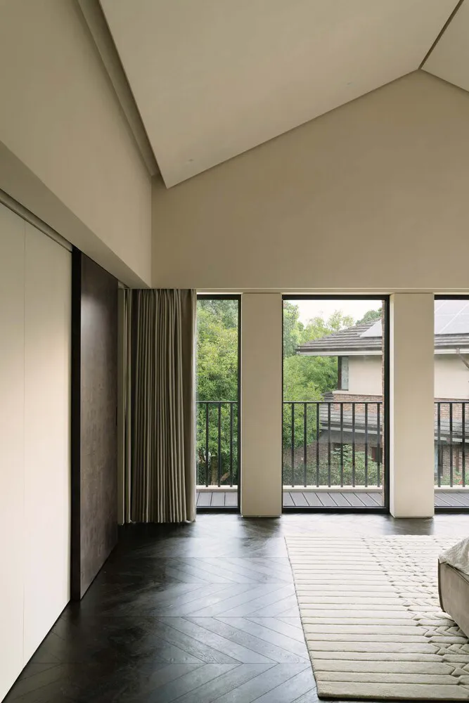 現代住宅室內,木質地板、大型窗戶,以及可俯瞰綠意的陽台。
