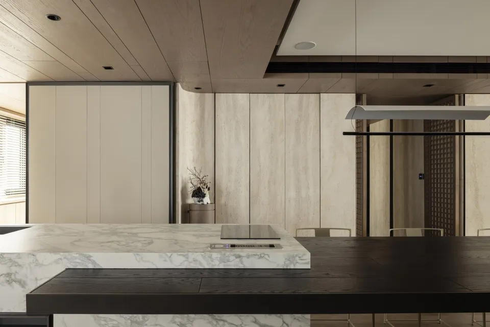 Modern minimalist interior space featuring a wooden kitchen counter and dining table with a minimalist design.