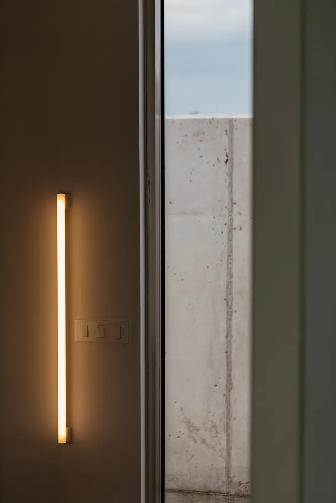 A minimalist interior design featuring concrete structures and warm lighting.