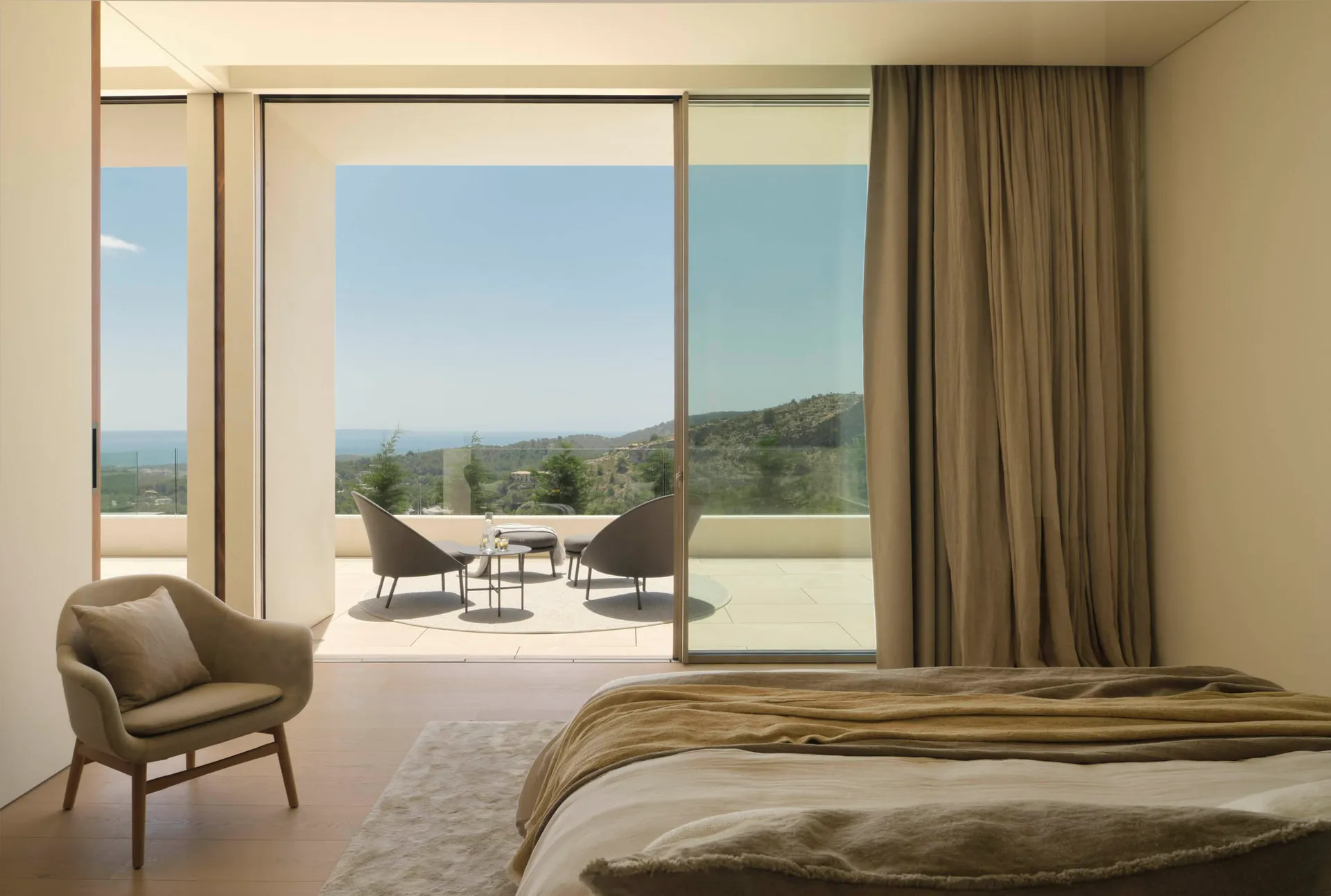 Modern bedroom featuring wooden floors, linen bedding, and glass windows with a view of the hills and sea.