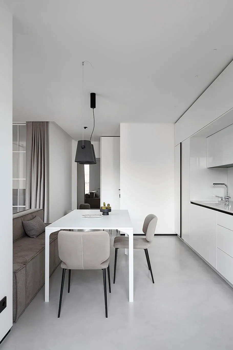 A modern dining room with white furniture and minimalist design.