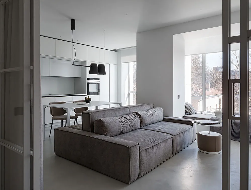 A modern living room with light grey upholstered furniture and minimalist design.