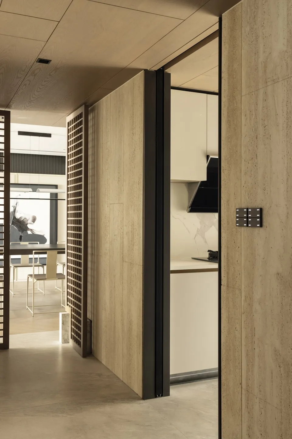 A modern minimalist kitchen with an open-concept layout, showcasing sleek, light-colored wooden cabinetry and a smooth, conti