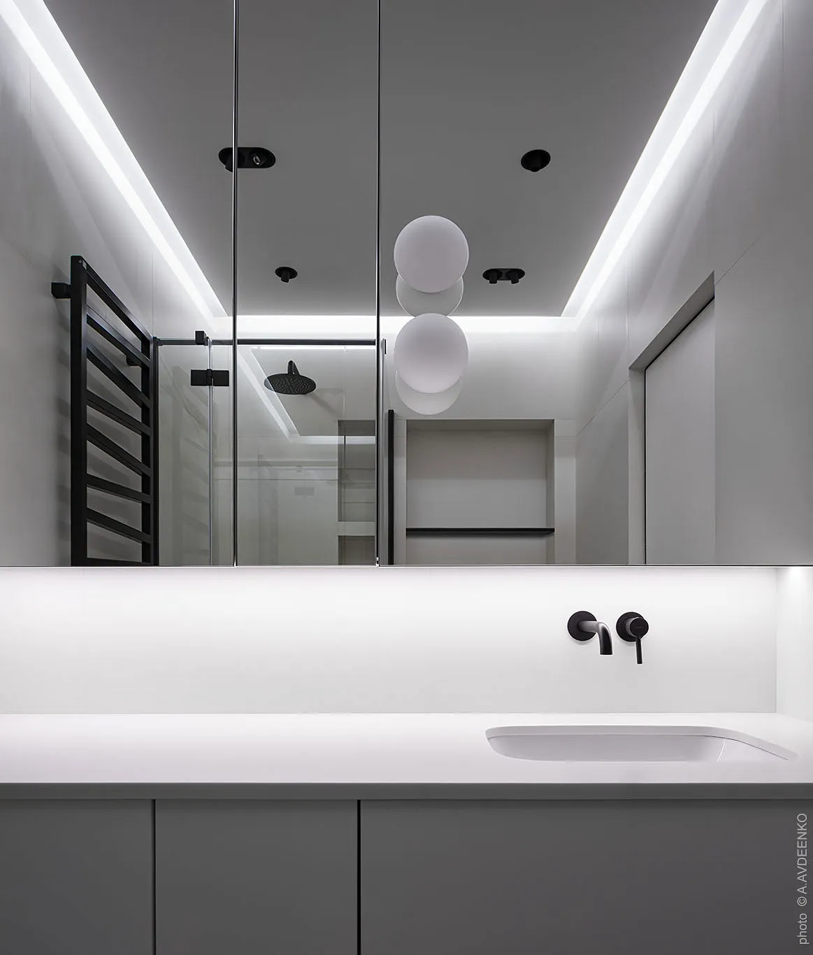 A modern minimalist white bathroom with sleek lines and a neutral color palette.