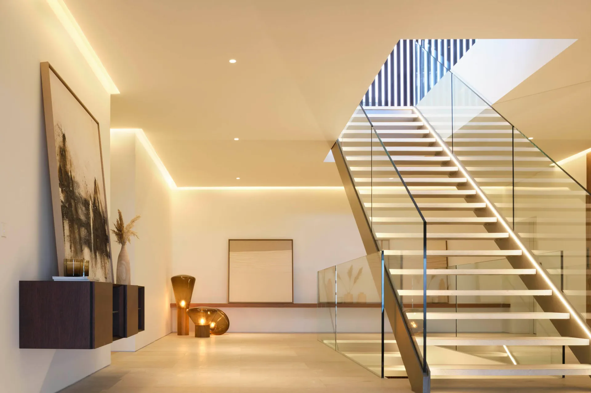 A modern staircase with glass railings and white steps.