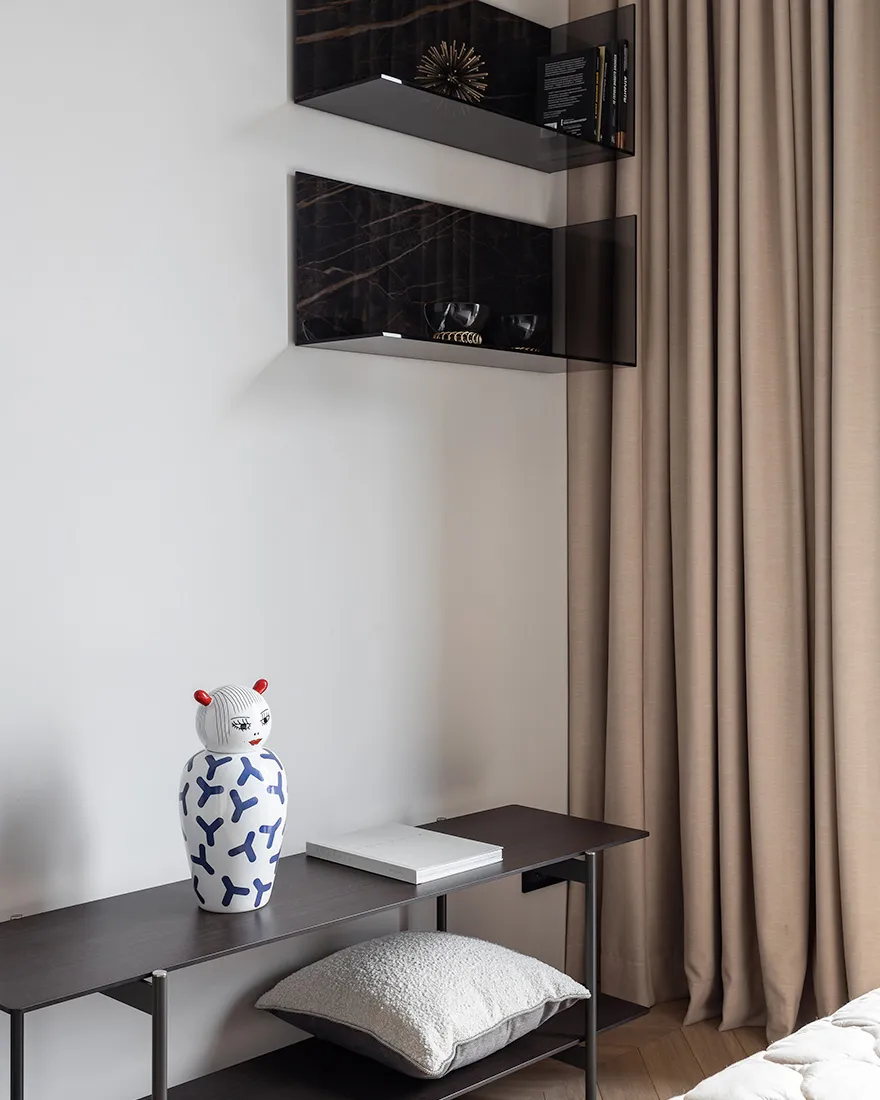 A minimalist bedroom featuring glass and marble decor elements.