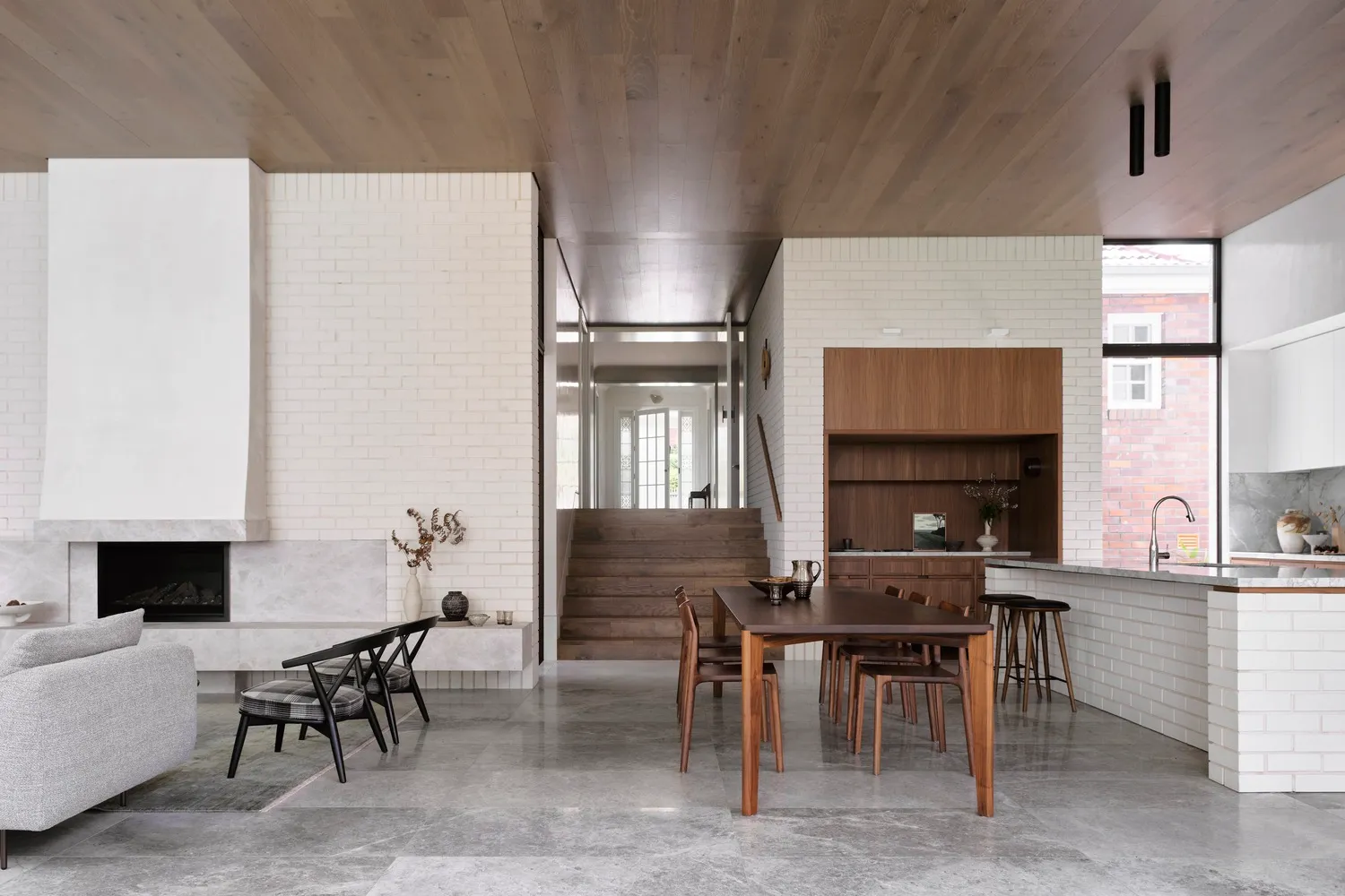 Modern residential kitchen featuring concrete, brick, and wood materials with a minimalist design.