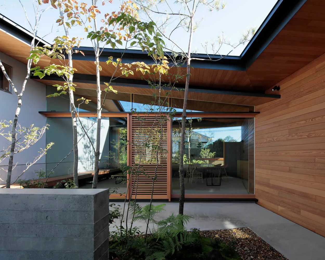 A modern exterior with wooden elements and a concrete planter.