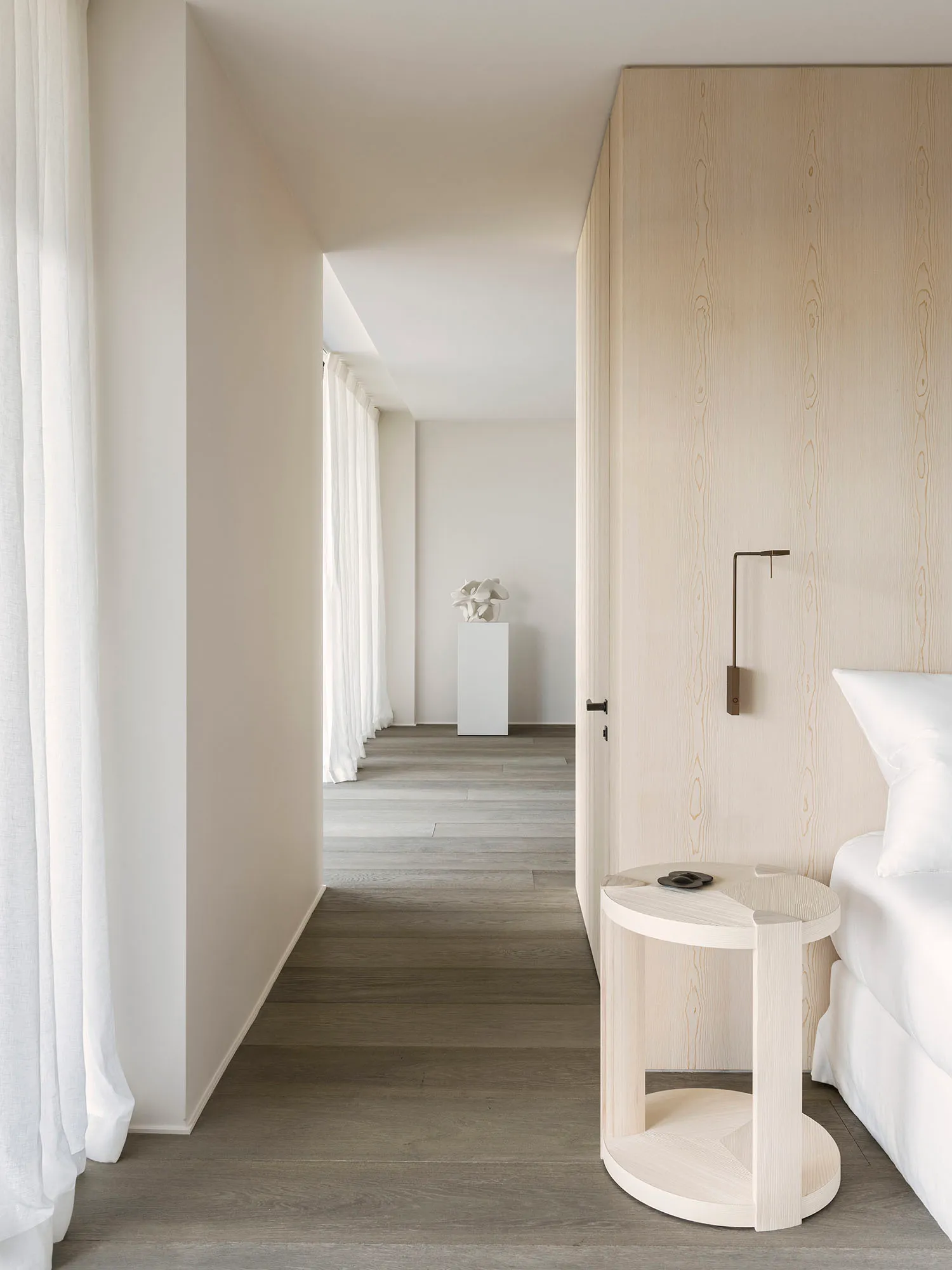 Modern minimalist bedroom with natural wood accents and linen curtains.