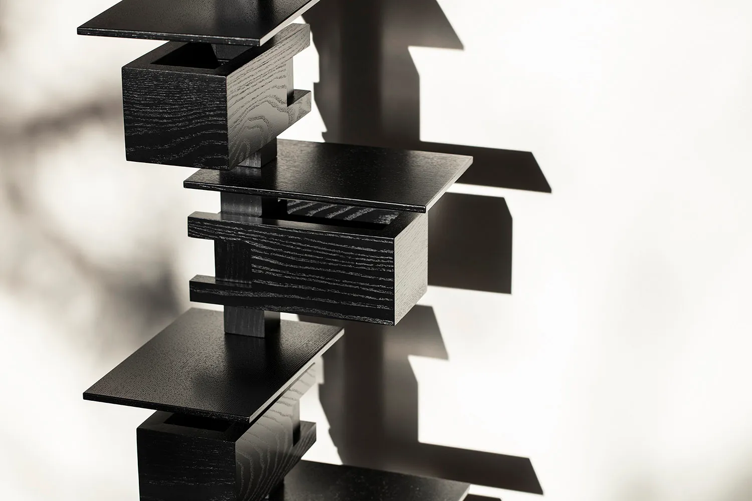 A modern, black, wooden floating shelf system.