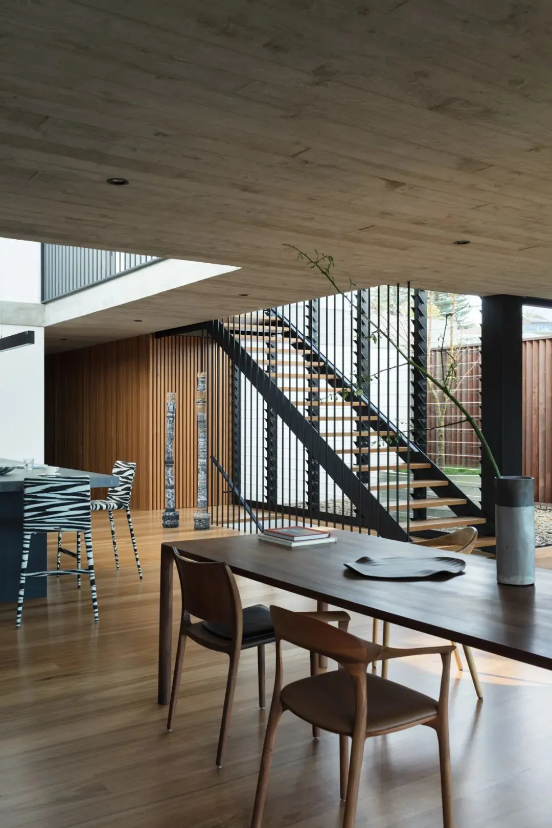 Modern industrial dining room featuring wooden tables, concrete flooring, and steel accents.