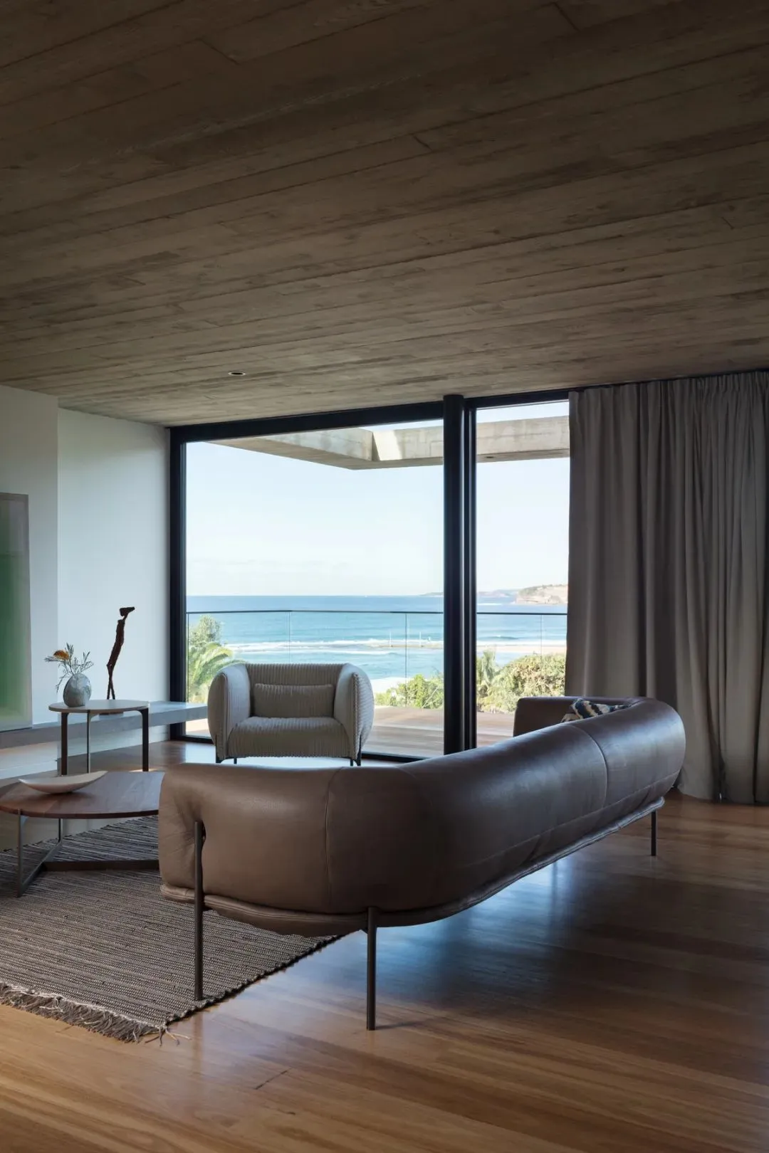 Contemporary living room featuring modern leather furniture and concrete ceiling