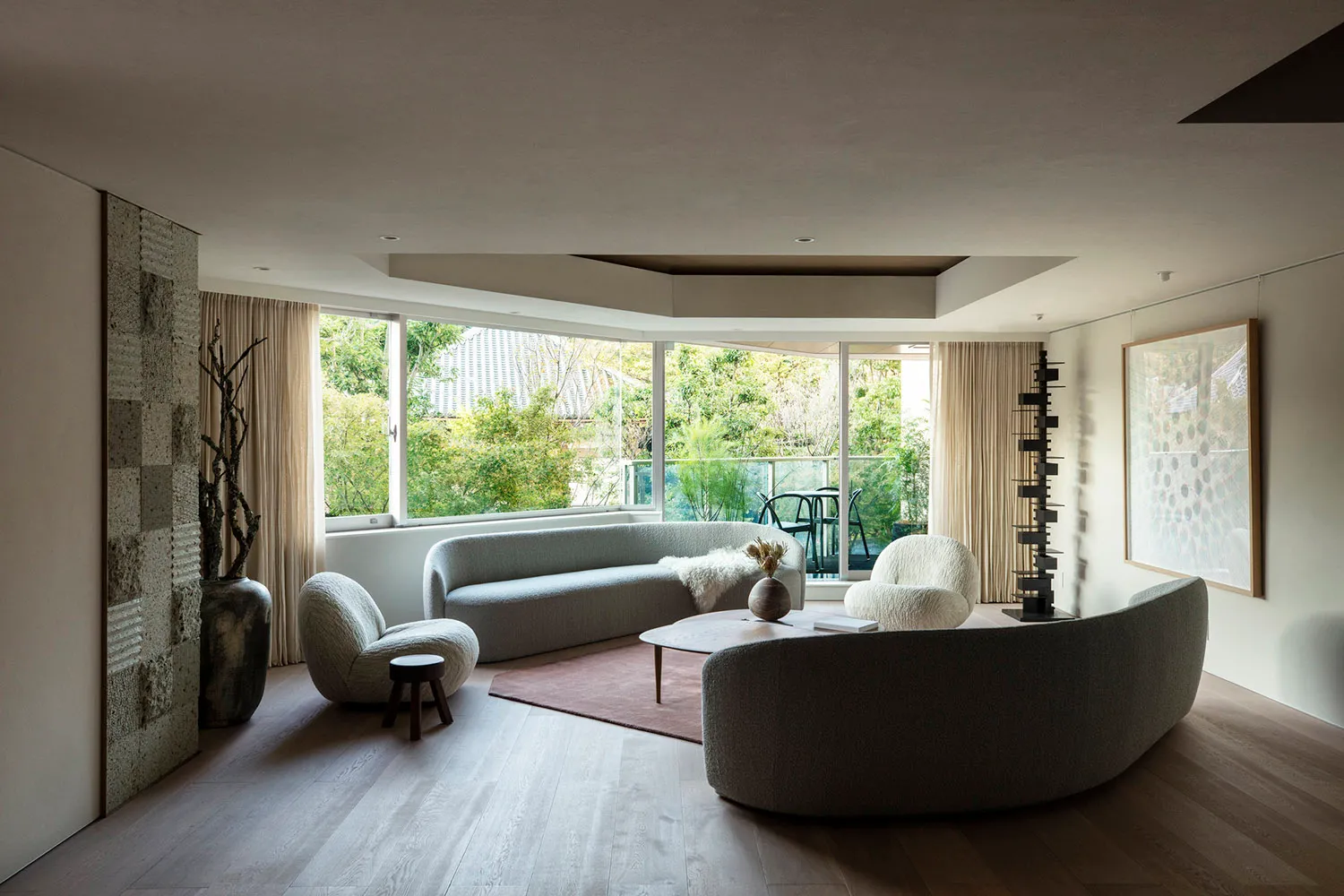 A modern living room with textured fabric furniture and large windows.