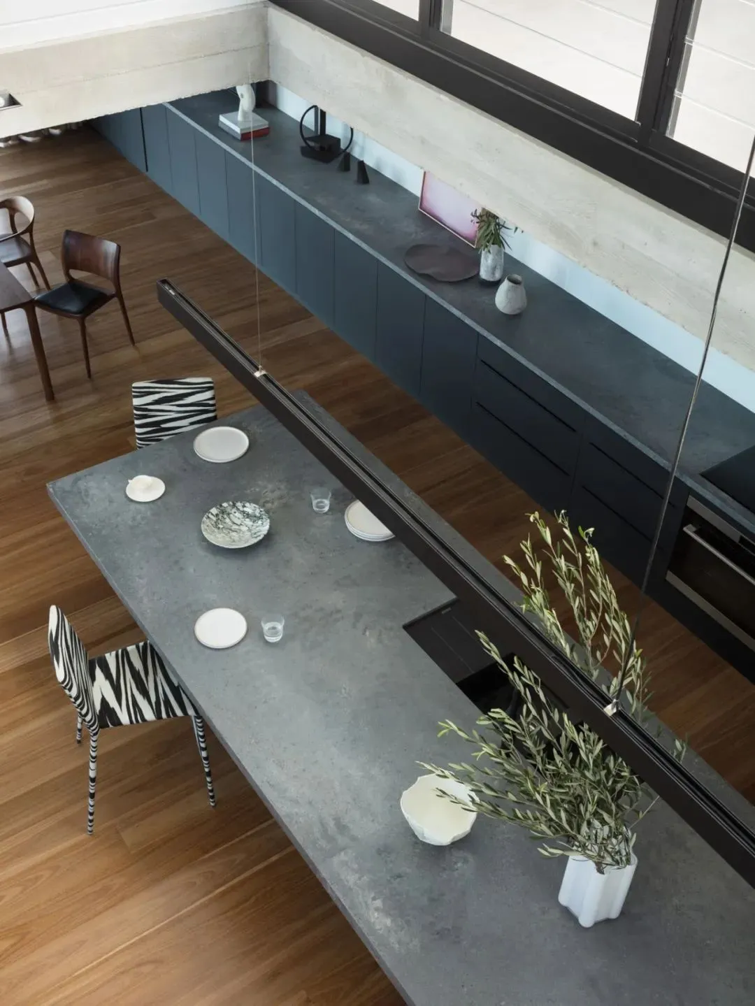 A modern, industrial kitchen with concrete countertops and minimalist decor.