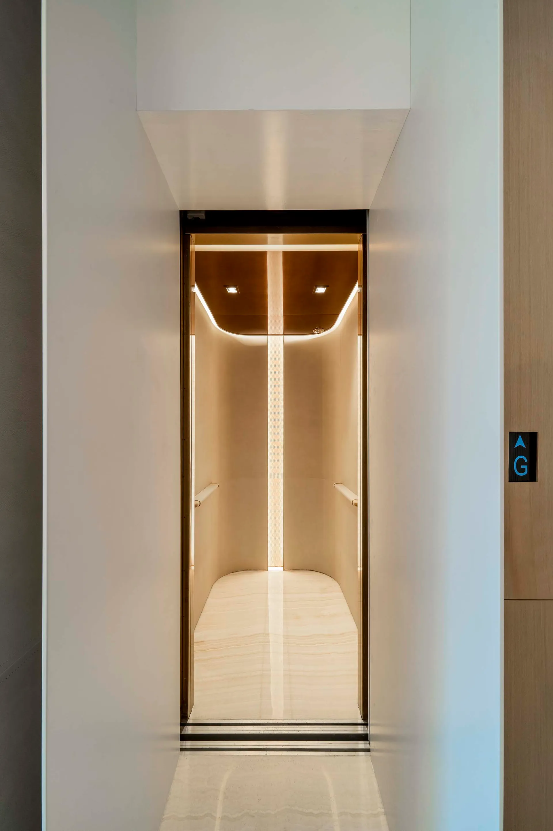 Modern, luxurious elevator interior with warm lighting and minimalist design.
