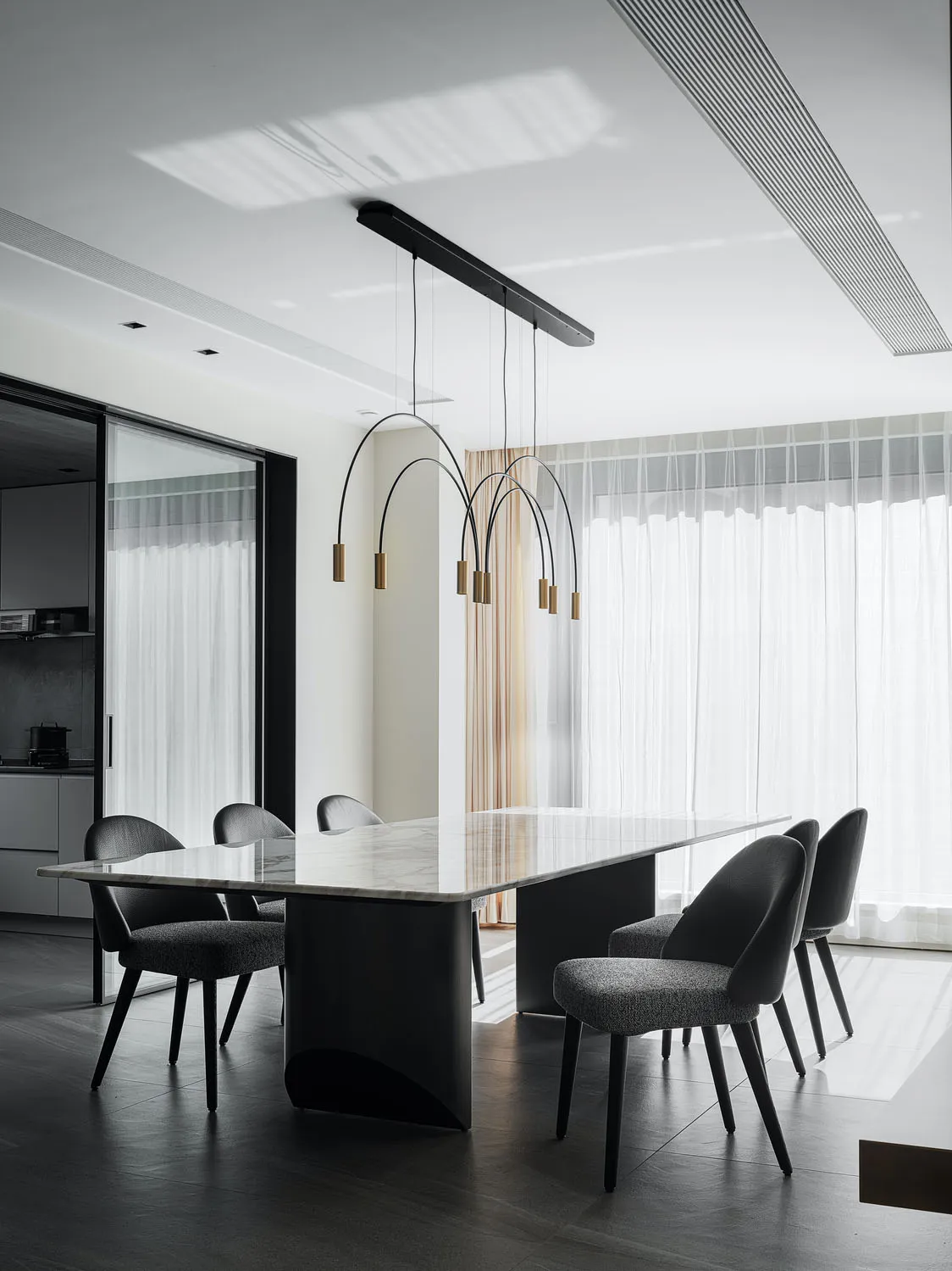 Modern dining room with marble table and black furniture.