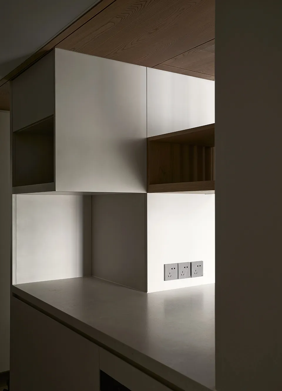 Modern minimalist kitchen with white concrete countertops and sleek, clean lines.