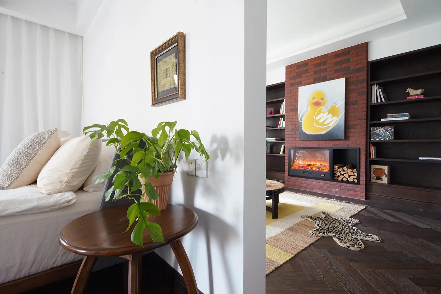 A modern living room featuring wooden furniture, brick accent wall, and a plush sofa with pillows.