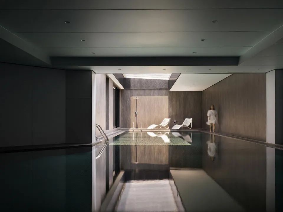 Modern spa interior with glass water feature and stone walls.
