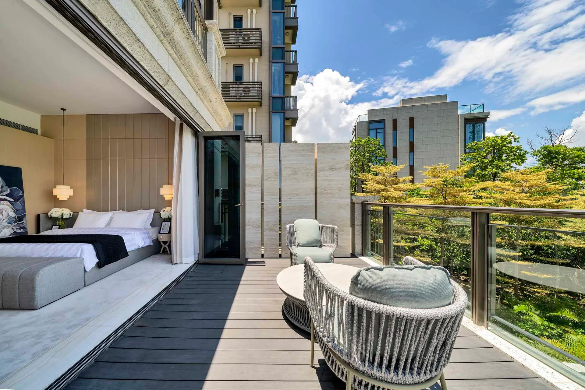 Modern residential balcony featuring metal elements, glass dividing walls, and wooden flooring.