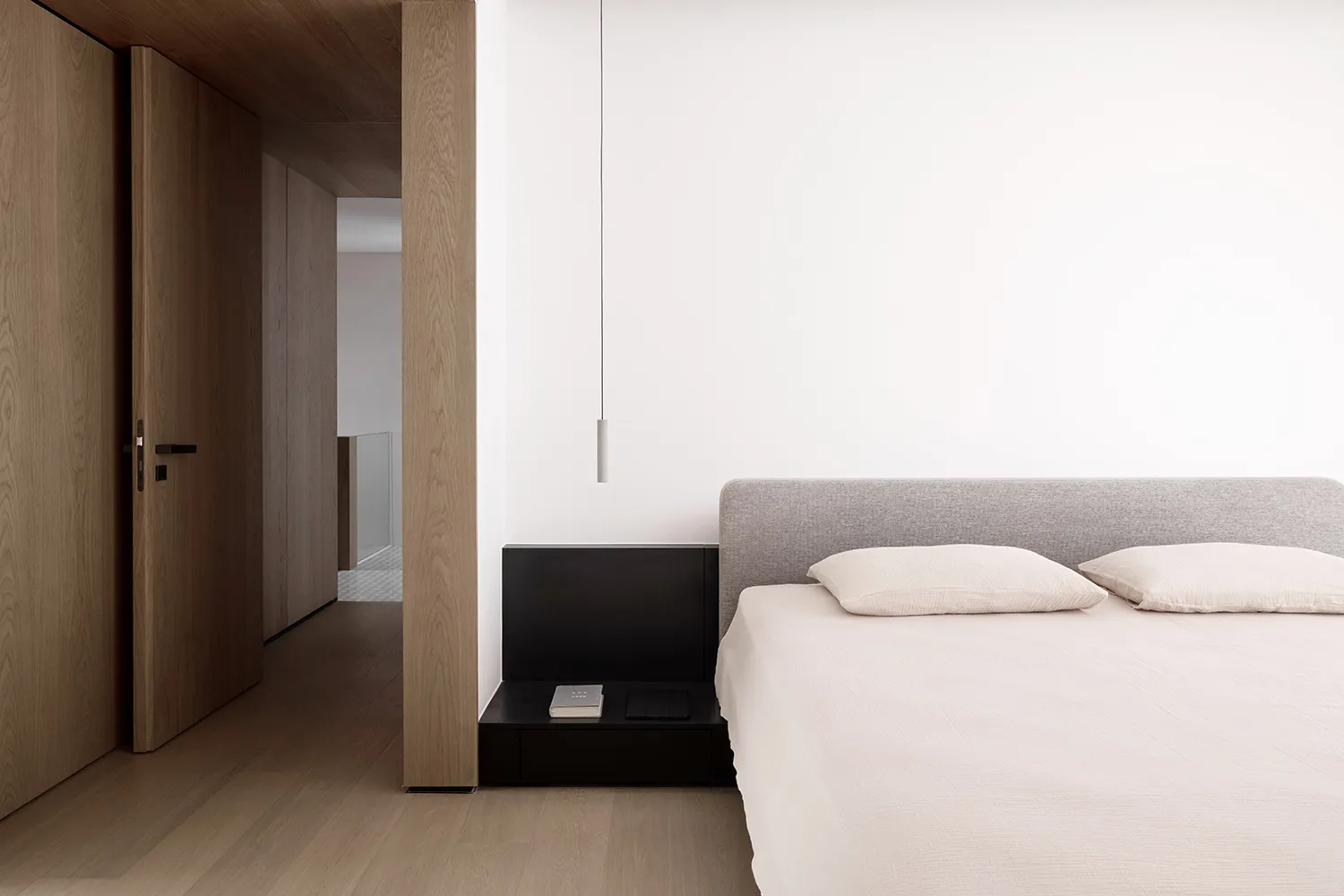 Minimalist bedroom featuring a textured wood floor and marble countertop