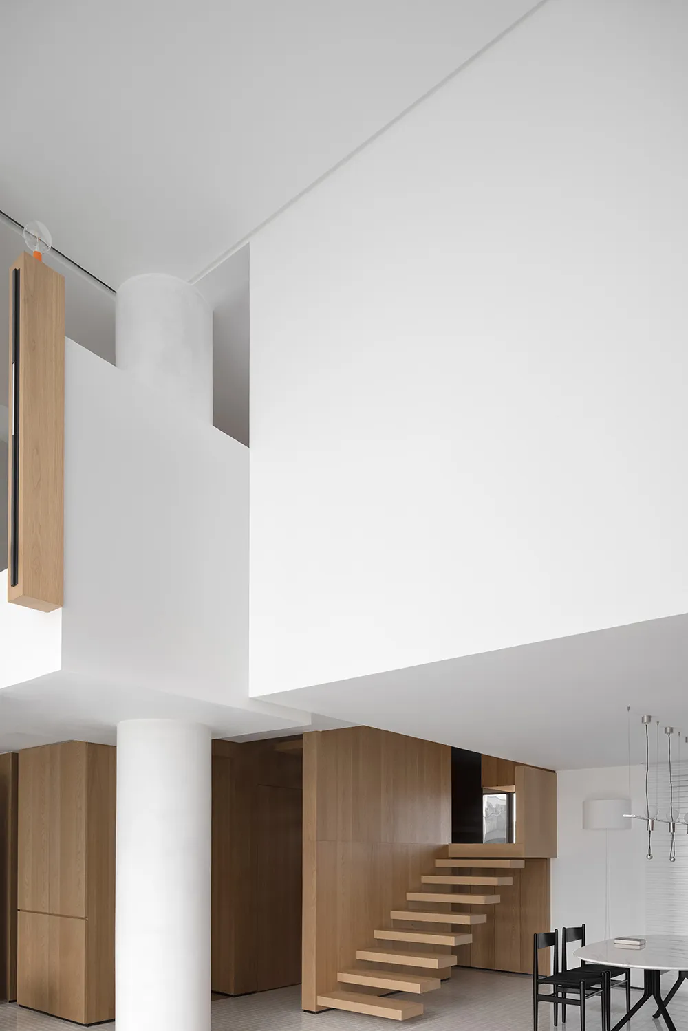A minimalist interior design featuring white walls and wooden elements.