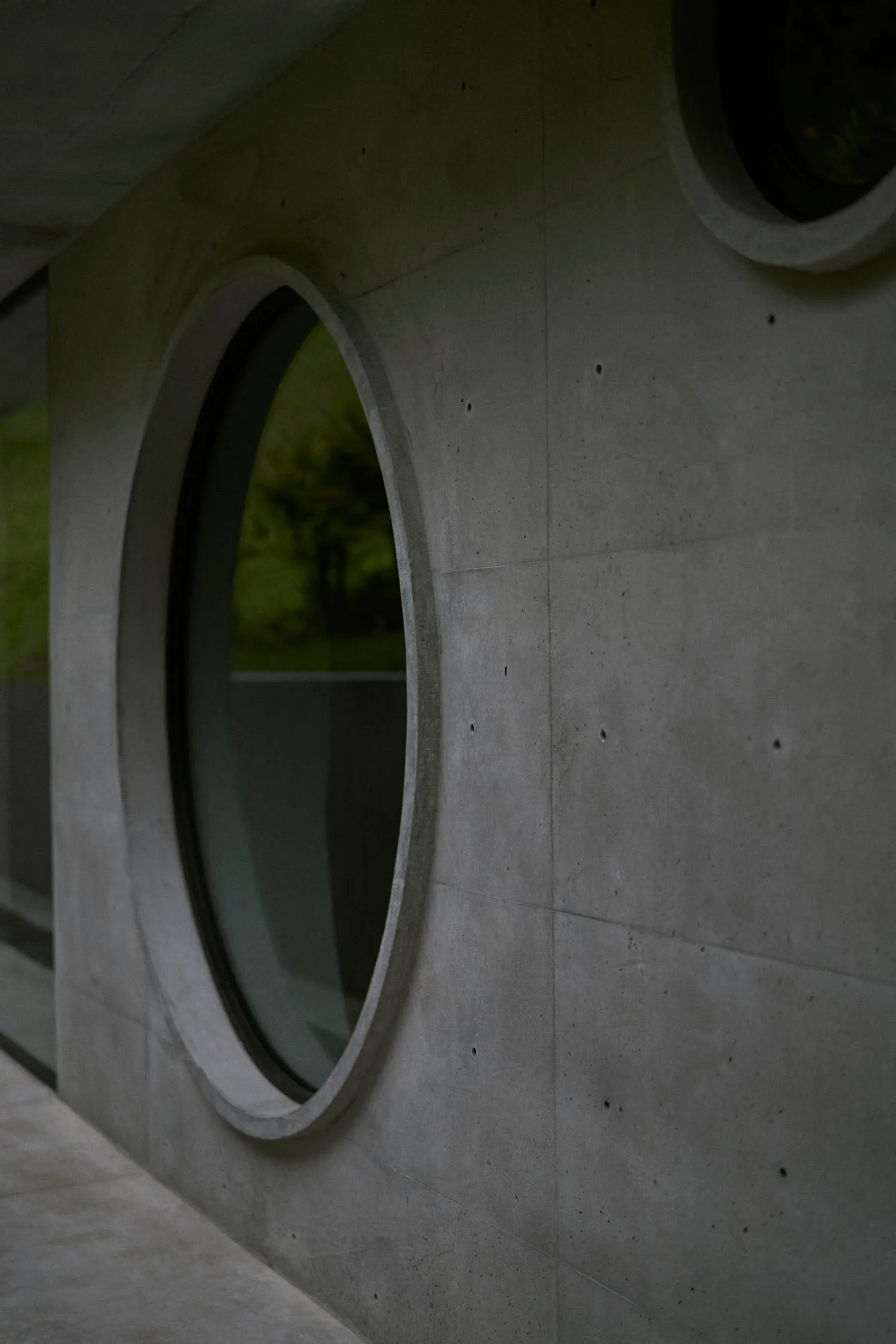 A modern concrete exterior featuring circular windows.