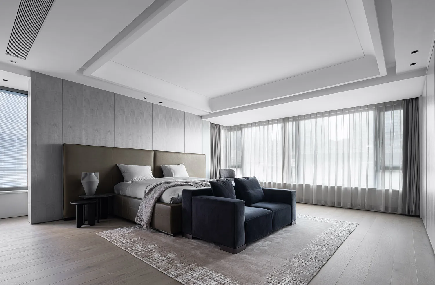A modern minimalist bedroom featuring textured wall paneling