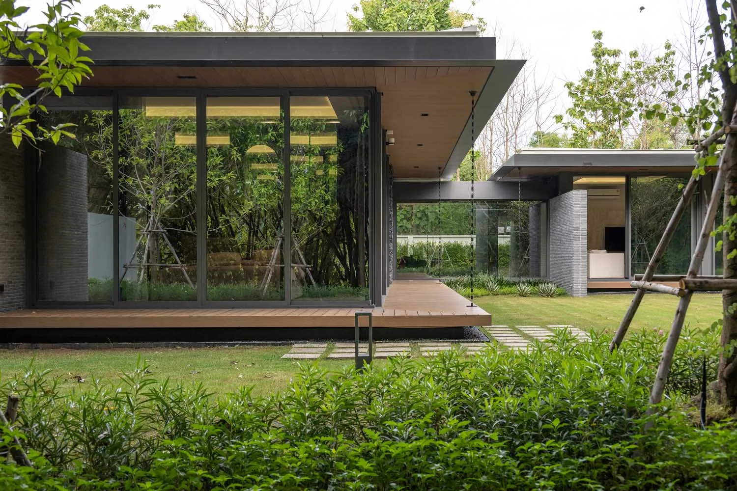 Modern minimalist home with glass walls and concrete exterior.