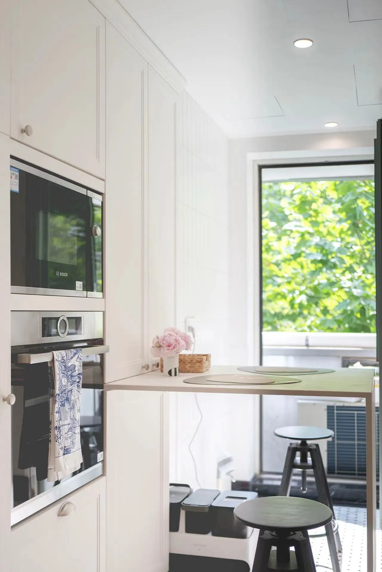 A minimalist kitchen with white cabinets and modern appliances.